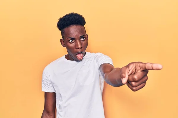 若いアフリカ系アメリカ人の男性は 指を前に 口を開けて驚いた表情 何かを前に驚いてカジュアルな服を着て — ストック写真