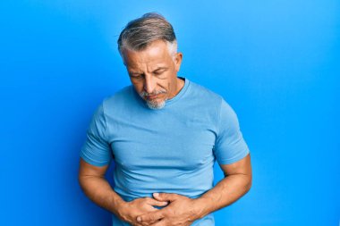 Orta yaşlı, gri saçlı, elleri karnında günlük kıyafetler giyen bir adam. Çünkü hazımsızlık, acı verici bir hastalık ve kendini iyi hissetmiyor. Ağrı kavramı. 