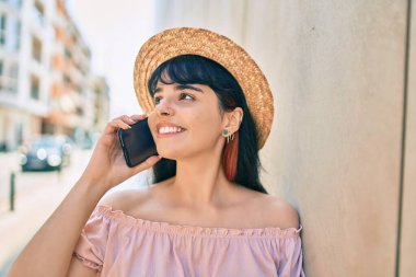 Yaz stili giyinmiş genç İspanyol turist kız şehirde akıllı telefondan konuşuyor..