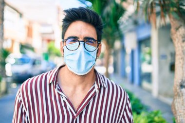 Koronavirüs güvenlik maskesi takan, dışarıda sakallı, yakışıklı bir İspanyol.