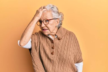 Üstün gri saçlı, günlük kıyafetler giyen ve gözlük takan bir kadın. Yanlışlıkla el ele tutuşarak şaşırmış. Hatayı hatırla. Unuttum, kötü hafıza kavramı. 