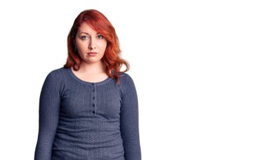 Genç, güzel, kızıl saçlı, sıradan bir tişört giyen, yüzünde ciddi bir ifade olan bir kadın. Basit ve doğal bir şekilde kameraya bakıyorsun.. 