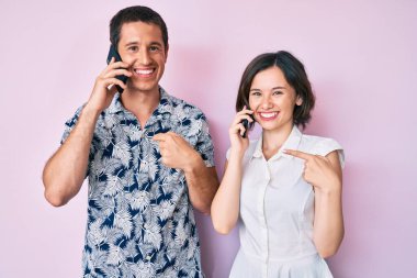 Akıllı telefondan konuşan güzel bir çift mutlu ve gururlu bir gülümsemeyi işaret ediyor. 