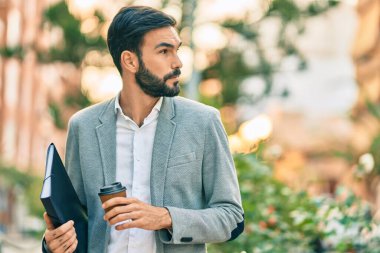 Genç İspanyol işadamı mutlu bir şekilde gülümsüyor, şehirde kahve içiyor..