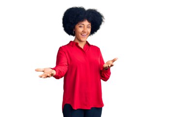 Genç Afro-Amerikan kızı, günlük kıyafetler giyip neşeli gülümseyerek yardım eli uzatıyor ve kabul ediyor.. 