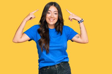 Güzel, esmer, sıradan kıyafetler giyen, iki eliyle başını gösteren güzel bir kadın. Harika bir fikir ya da düşünce, iyi bir hafıza. 