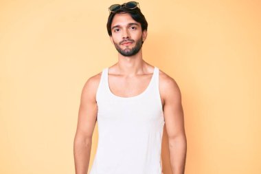 Yaz bakışı ve güneş gözlüğü takan yakışıklı İspanyol adam yüzünde ciddi bir ifadeyle rahatlamış. Basit ve doğal bir şekilde kameraya bakıyorsun.. 