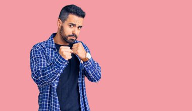 Latin asıllı genç adam gündelik giysiler giyiyor. Yumruk savunma hareketiyle dövüşmeye hazır. Kızgın ve üzgün yüz, sorundan korkuyor. 