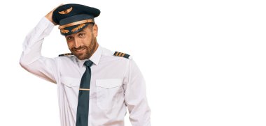 Uçak pilotu üniforması giyen sakallı yakışıklı adam soru sormayı merak ediyor. Şüpheyle kararsız, kafa kafaya düşünerek. Düşünceli kavram. 