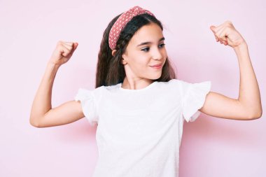 Sıradan kıyafetler giyen tatlı İspanyol kız ve Diadem gururla gülümseyen kol kaslarını gösteriyor. fitness konsepti. 