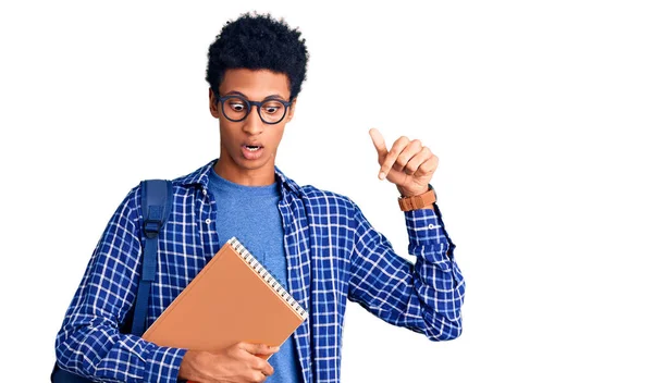 若いですアフリカ系アメリカ人男性身に着けています学生バックパック保持本指して指で示す広告 驚きの顔とオープン口 — ストック写真