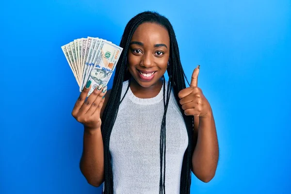 Joven Mujer Afroamericana Sosteniendo Dólares Sonriendo Feliz Positivo Pulgar Hacia —  Fotos de Stock