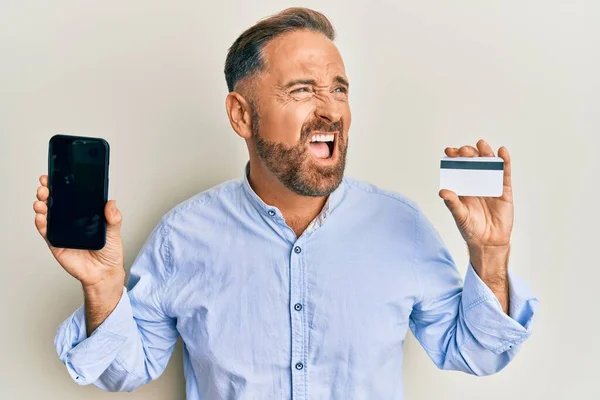 Bonito Homem Meia Idade Segurando Smartphone Cartão Crédito Irritado Louco — Fotografia de Stock