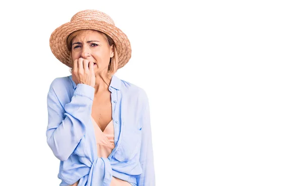夏の帽子をかぶっている若いブロンドの女性は 口の中で爪をかむ上で手でストレスと緊張している 不安の問題 — ストック写真