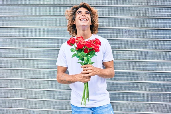 Jovem Homem Hispânico Bonito Sorrindo Feliz Segurando Buquê Rosas Rua — Fotografia de Stock