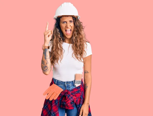 Young Hispanic Woman Tattoo Wearing Hardhat Builder Clothes Pointing Finger — 图库照片