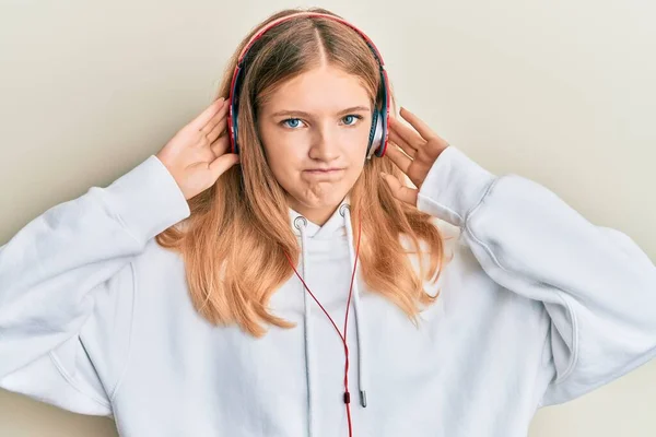 Vacker Ung Kaukasiska Flicka Lyssnar Musik Med Hörlurar Skeptisk Och — Stockfoto