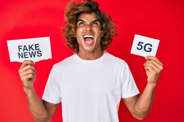 Young Hispanic Man Holding Fake News Banner Angry Mad Screaming — Stock Photo, Image