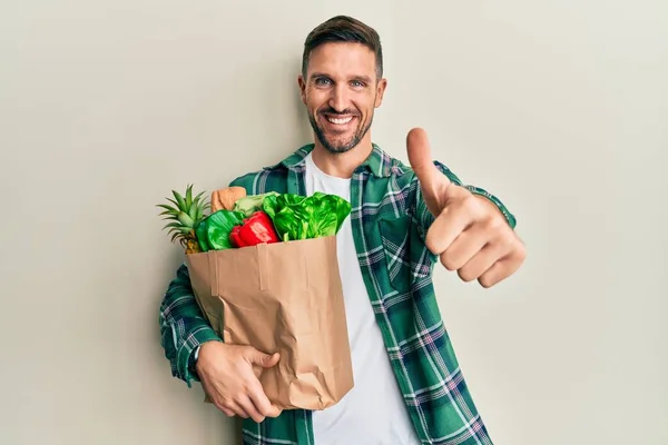 Homem Bonito Com Barba Segurando Saco Papel Com Mantimentos Aprovando — Fotografia de Stock