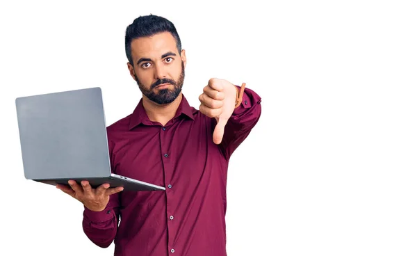 Jonge Spaanse Man Houdt Laptop Met Boos Gezicht Negatief Teken — Stockfoto