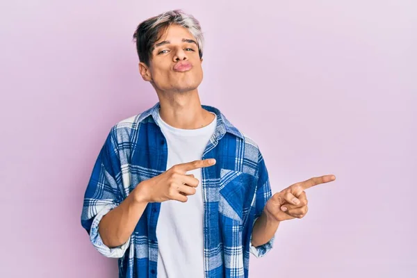 Jovem Hispânico Apontando Com Dedos Para Lado Olhando Para Câmera — Fotografia de Stock