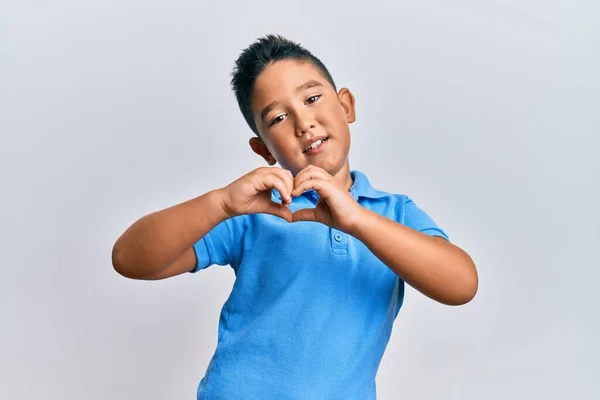 心のシンボルと手で形を示す愛に笑みを浮かべてカジュアルな服を着て小さな男の子のヒスパニック系の子供 ロマンチックなコンセプト — ストック写真