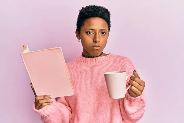 若いアフリカ系アメリカ人の女の子は本を読んでコーヒーを飲んで落ち込んでおり 苦痛のために心配し 怒って恐れて泣いています 悲しい表情 — ストック写真