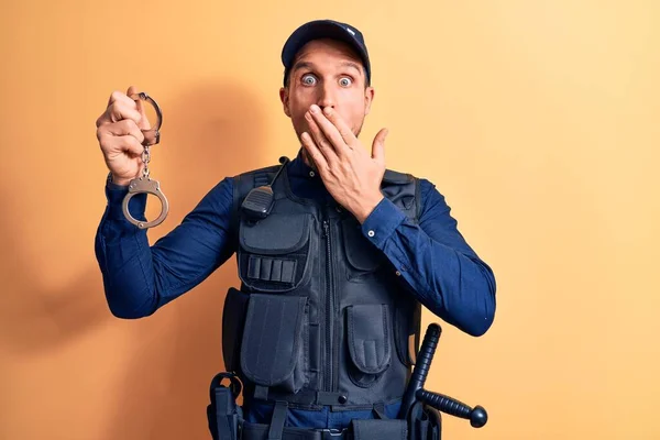 Snygg Polis Bär Uniform Och Bulletprof Hålla Handbojor Över Gul — Stockfoto