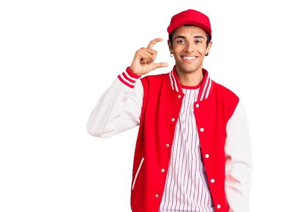 年轻的非洲裔美国人 身穿棒球制服 面带微笑 自信地做手势 手拿着小尺寸的标志 手拿着手指 手拿着相机 计量概念 — 图库照片
