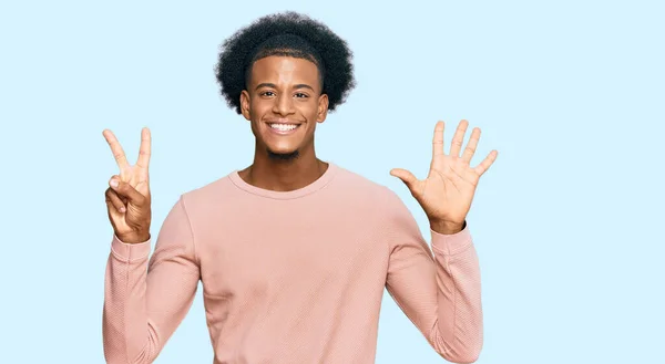 アフリカ系アメリカ人の男とアフロの髪を着てカジュアルな服を見せ 指の番号7を指摘しながら 自信と幸せ笑みを浮かべて — ストック写真