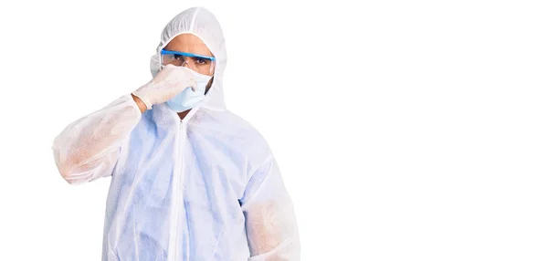 Młody Hiszpan Noszący Mundur Koronawirusa Maskę Medyczną Wąchający Coś Śmierdzącego — Zdjęcie stockowe