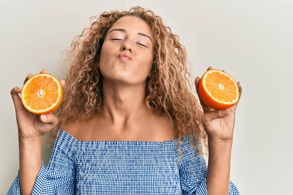 Hermosa Chica Adolescente Caucásica Sosteniendo Naranja Fresca Mirando Cámara Soplando —  Fotos de Stock