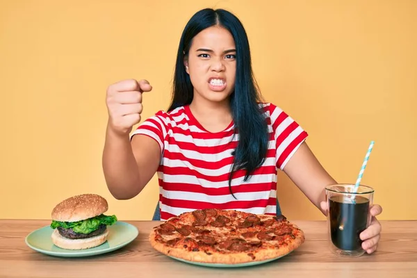 Młoda Piękna Azjatycka Dziewczyna Jedząc Fast Food Pizza Burger Zirytowany — Zdjęcie stockowe