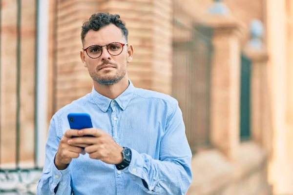 Joven Empresario Hispano Con Expresión Seria Usando Smartphone Ciudad —  Fotos de Stock