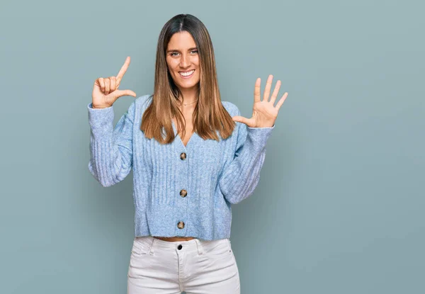 Młoda Kobieta Luźnych Ubraniach Pokazując Wskazując Palcami Numer Siedem Uśmiechając — Zdjęcie stockowe