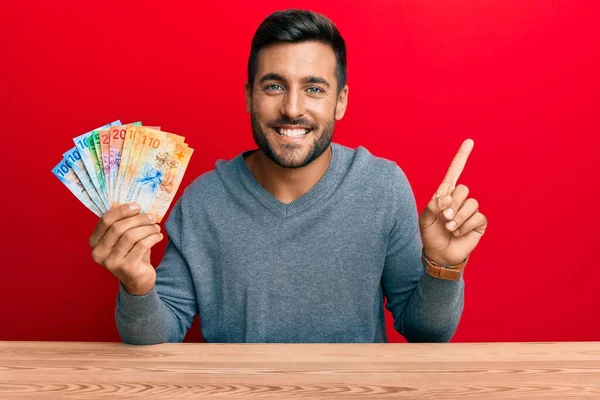 Hombre Hispano Guapo Sosteniendo Billetes Suizos Franco Sonriendo Feliz Señalando —  Fotos de Stock