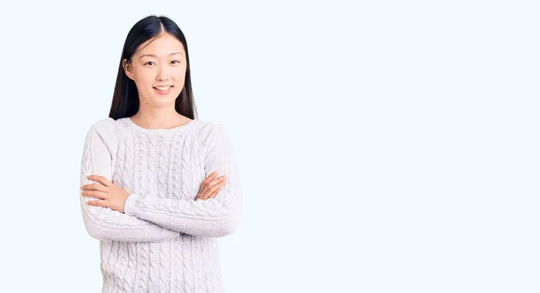 カジュアルなセーターを着た若い美しい中国人女性がカメラを見て腕を組んで笑顔で幸せな顔をしている 正の人 — ストック写真