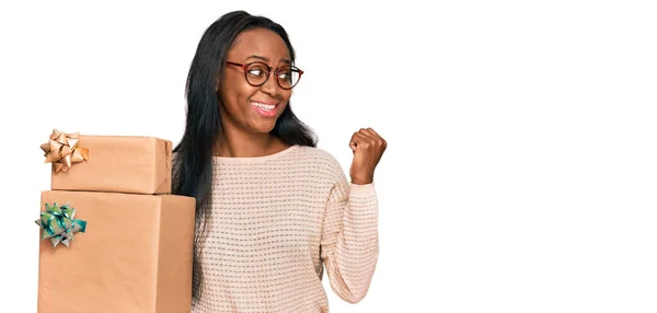 Jonge Zwarte Vrouw Met Geschenken Wijzen Duim Naar Zijkant Glimlachen — Stockfoto