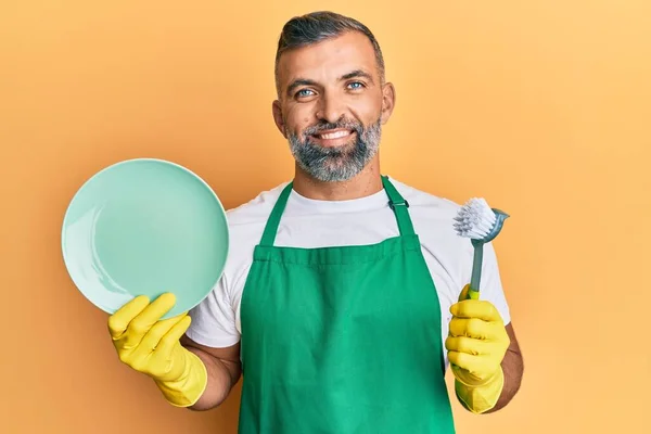 Homem Bonito Meia Idade Usando Avental Segurando Scourer Lavar Pratos — Fotografia de Stock