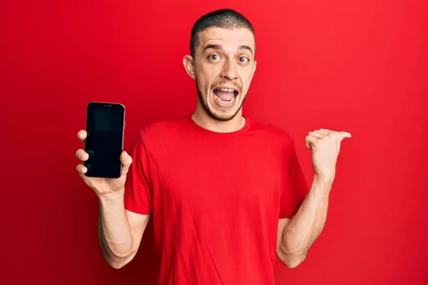 Joven Hispano Sosteniendo Teléfono Inteligente Mostrando Pantalla Blanco Apuntando Con —  Fotos de Stock