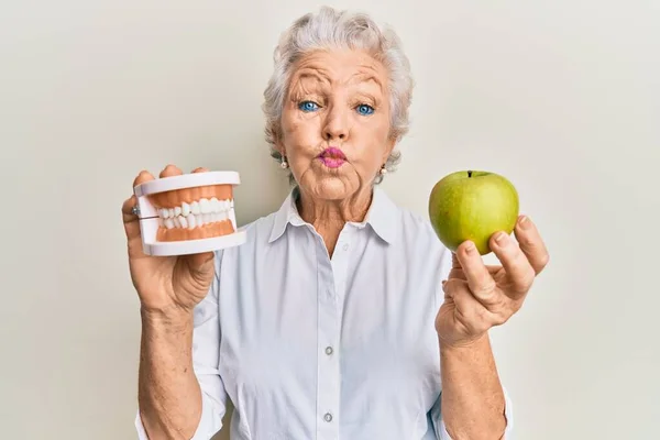 Senior Grey Haired Woman Holding Green Apple Denture Teeth Puffing — 图库照片