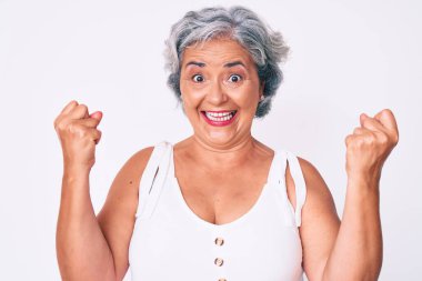 Kıdemli İspanyol kadın gündelik kıyafetler giyip gururla bağırıyor zaferi ve başarıyı kutluyor. Kollarını kaldırıp heyecanla bekliyor. 