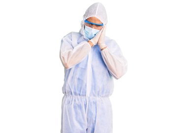 Genç İspanyol adam doktor koruması altında Coronavirus üniforması giyiyor ve sağlık maskesi takıyor. Uyuyor, uyuyor, hayal kuruyor ve ellerimiz kapalı gülümserken poz veriyor.. 