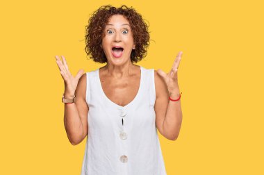 Güzel, orta yaşlı olgun bir kadın, sıradan beyaz bir gömlek giyip çılgınlığı kutluyor ve başarıya hayret ediyor. Kolları açık, gözleri açık, heyecanlı bir şekilde çığlık atıyor. Kazanan konsept 