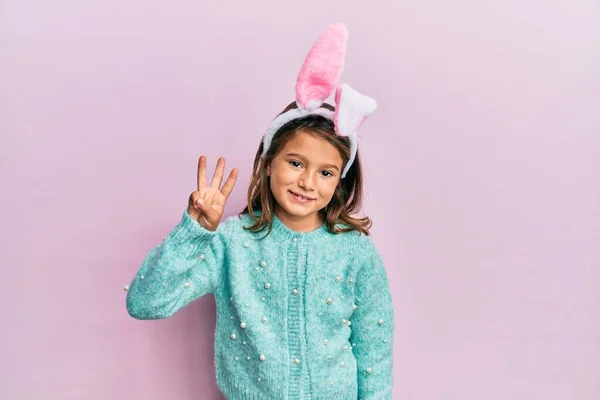 Gyönyörű Kislány Aranyos Húsvéti Nyuszifüleket Visel Mutatva Mutatva Fel Hármas — Stock Fotó