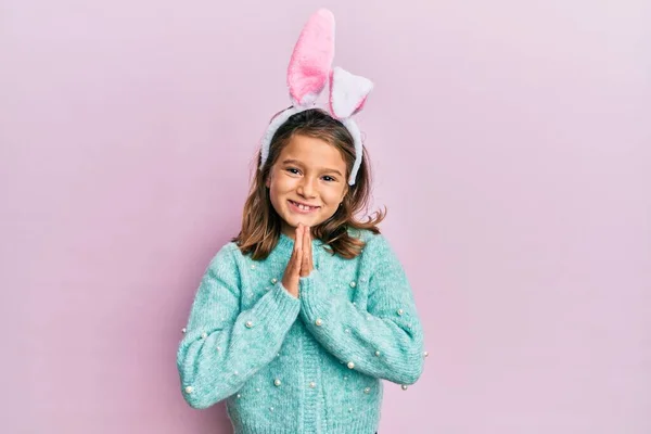 Gyönyörű Kislány Aranyos Húsvéti Nyuszifüleket Visel Kéz Kézben Imádkozik Bocsánatért — Stock Fotó