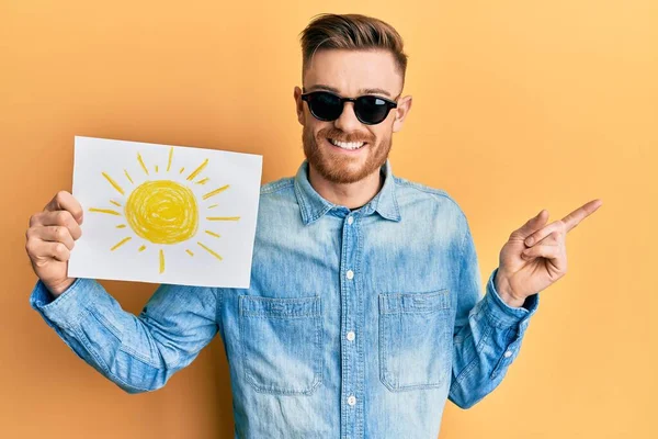 Mladý Rusovláska Muž Drží Slunce Čerpat Nosí Sluneční Brýle Usměvavý — Stock fotografie