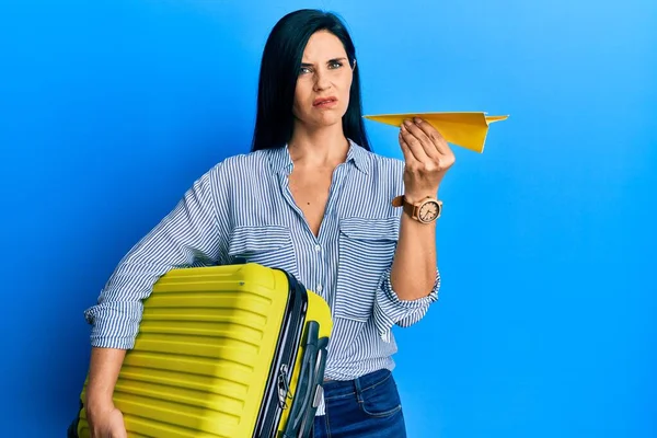 Junge Kaukasische Frau Mit Handtasche Und Papierflugzeug Skeptisch Und Nervös — Stockfoto