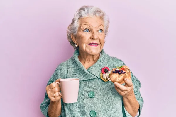 Starší Šedovlasá Žena Pije Šálek Kávy Housku Usmívá Dívá Stranou — Stock fotografie