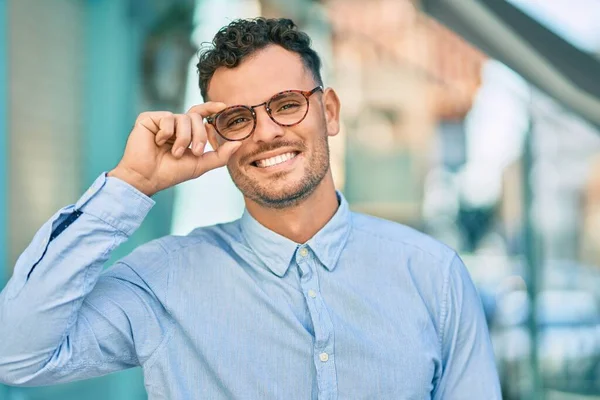 Jovem Empresário Hispânico Sorrindo Feliz Tocando Seus Óculos Cidade — Fotografia de Stock